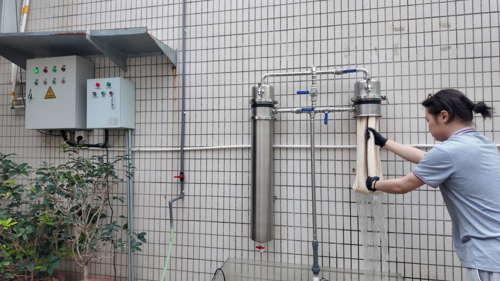 The user is manually rinsing ChengrongTimes ultrafiltration membrane fibers to remove trapped impurities and restore filtration performance.