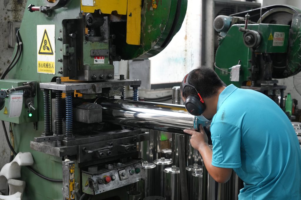 Chengrong UF Factory worker inspecting 304 stainless steel water purifier housings during manufacturing